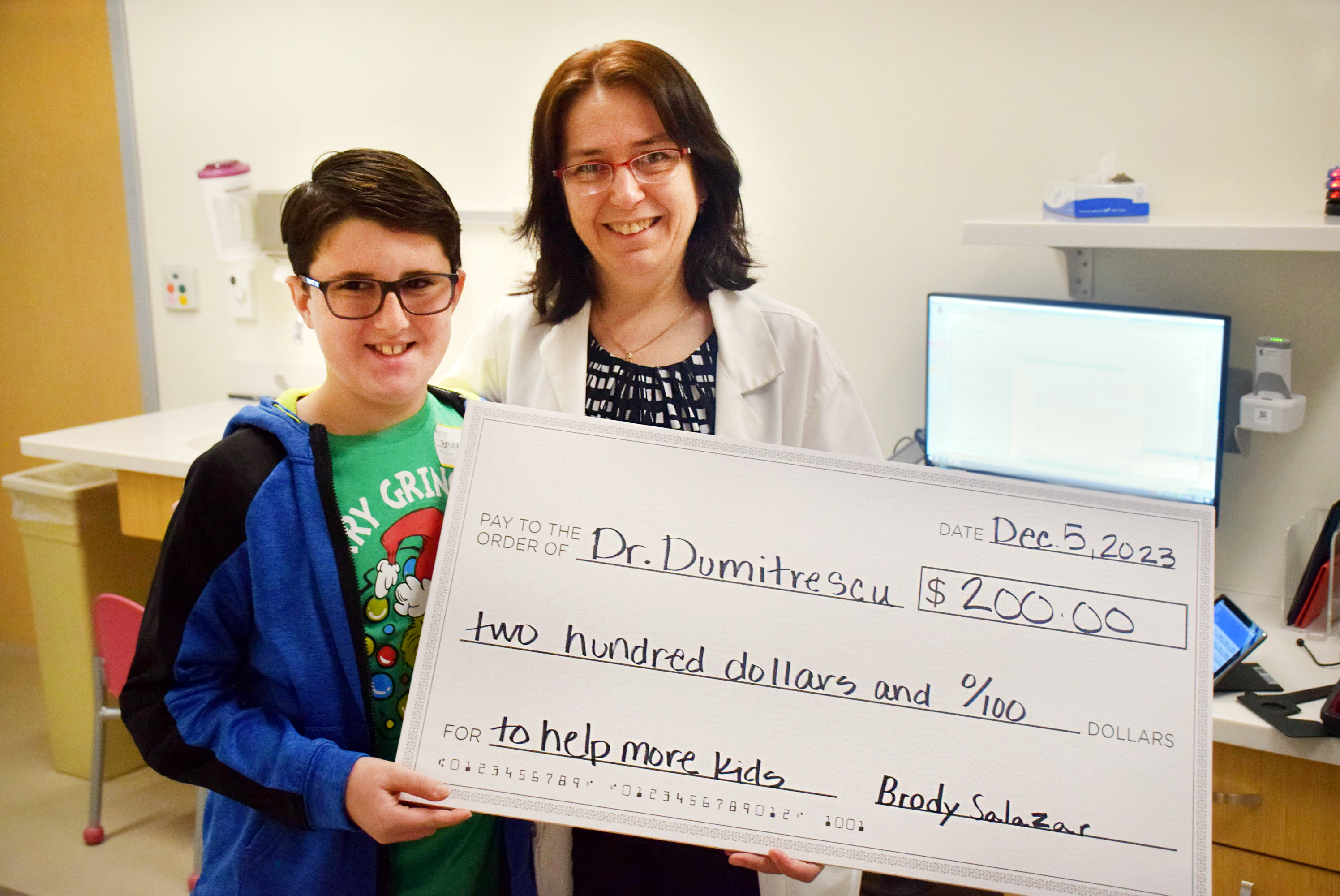 Patient presents check to Dr. Dumitrescu